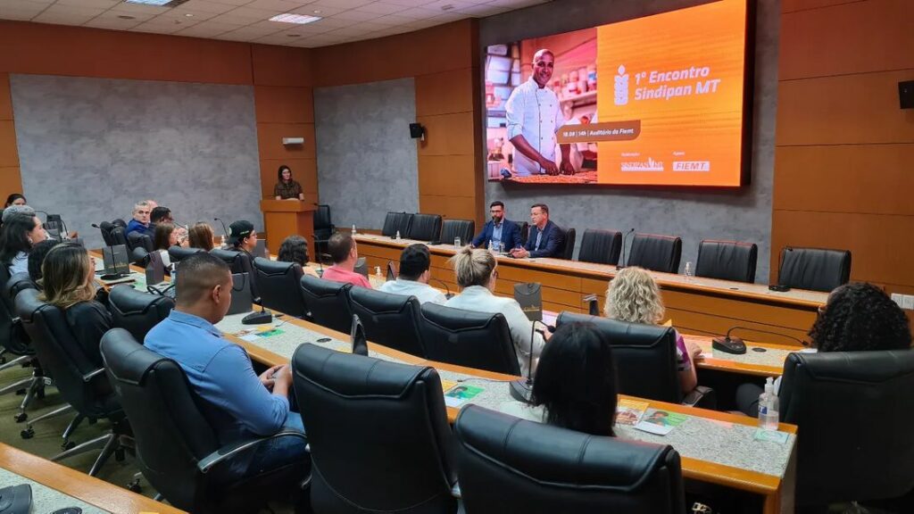 Participantes, sentados, em ambiente de auditório, durante o encontro do setor de panificação.